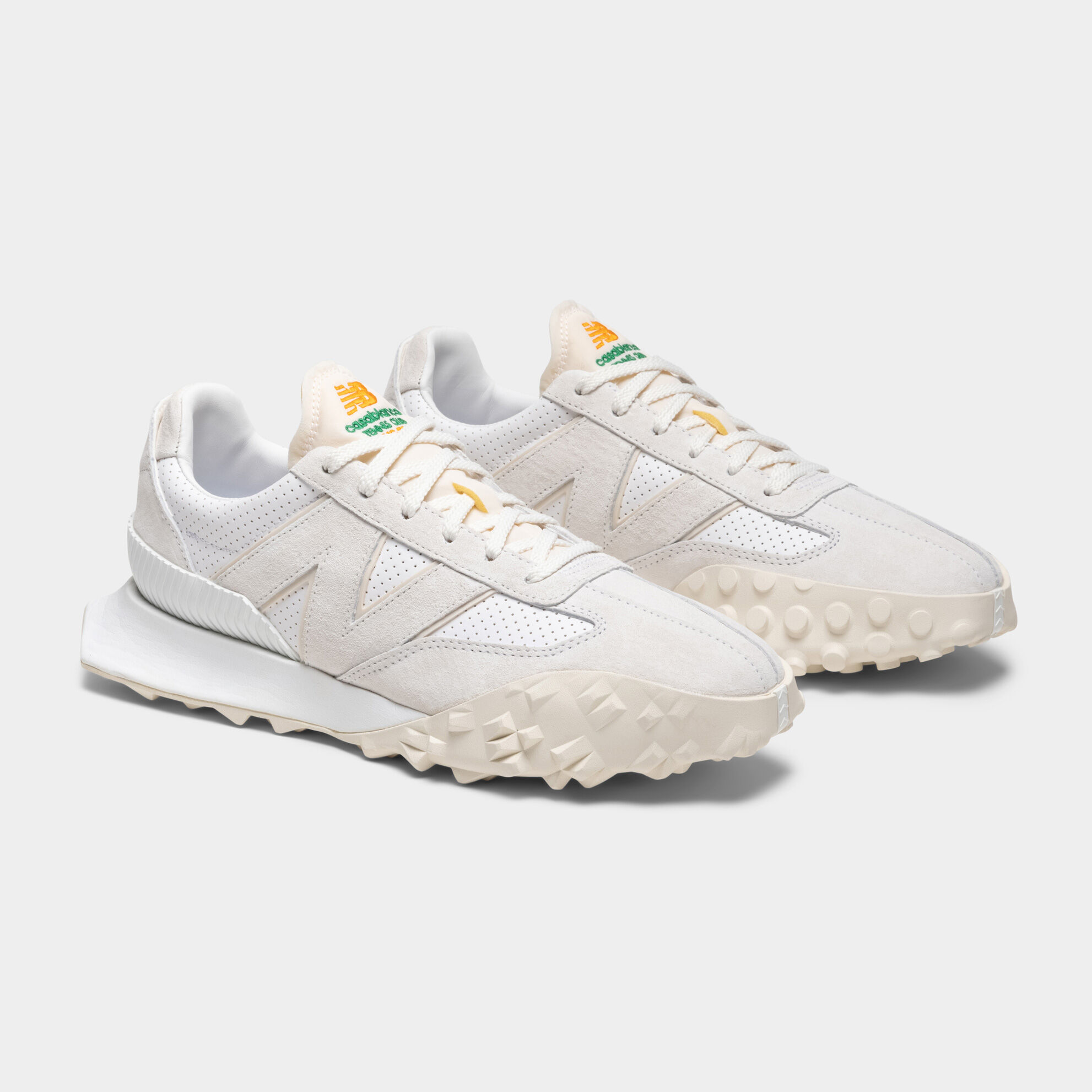 Pair of white Casablanca XC-72 sneakers sitting on a grey studio backdrop.