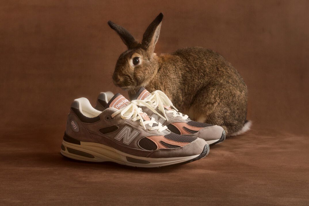 A pair of New Balance Made in UK sneakers sitting on a concrete floor.